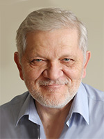 Dariusz Niedzieski Starszy mężczyzna z siwymi włosami i uśmiechem, ubrany w jasną koszulę.