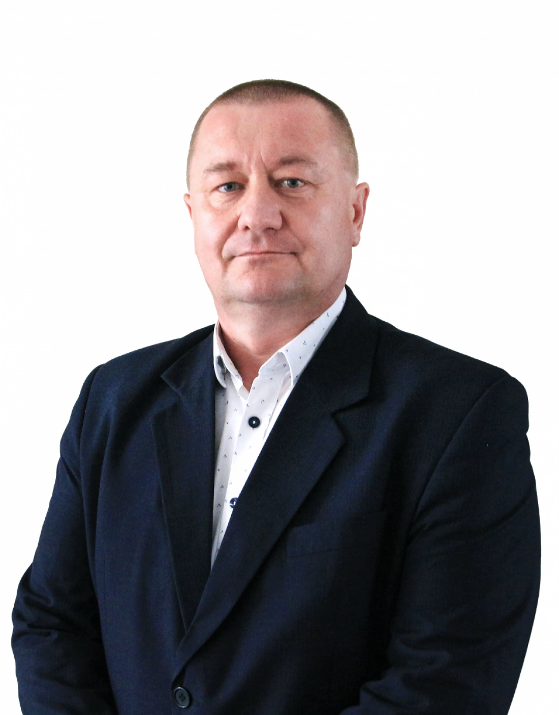 Mężczyzna w garniturze, stojący na neutralnym tle.