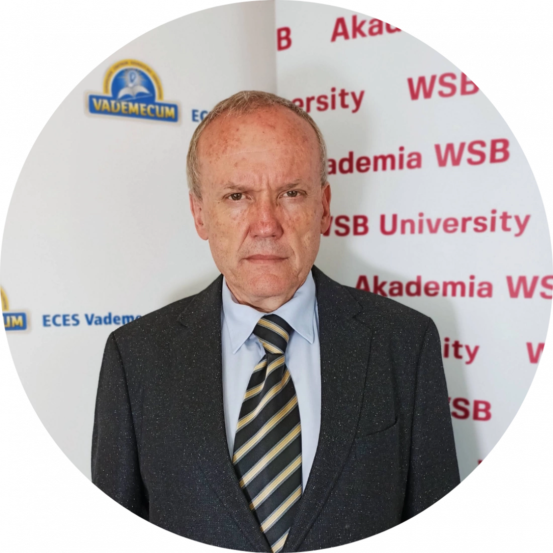 Mężczyzna w garniturze stoi na tle logo Akademii WSB.