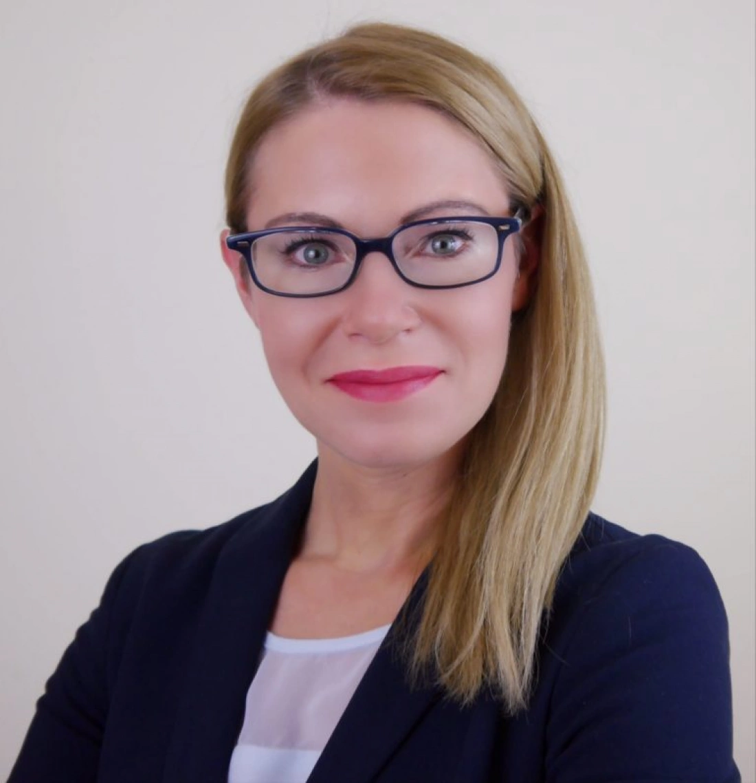 Profesjonalna portretowa fotografia kobiety w okularach, z uśmiechem na twarzy.