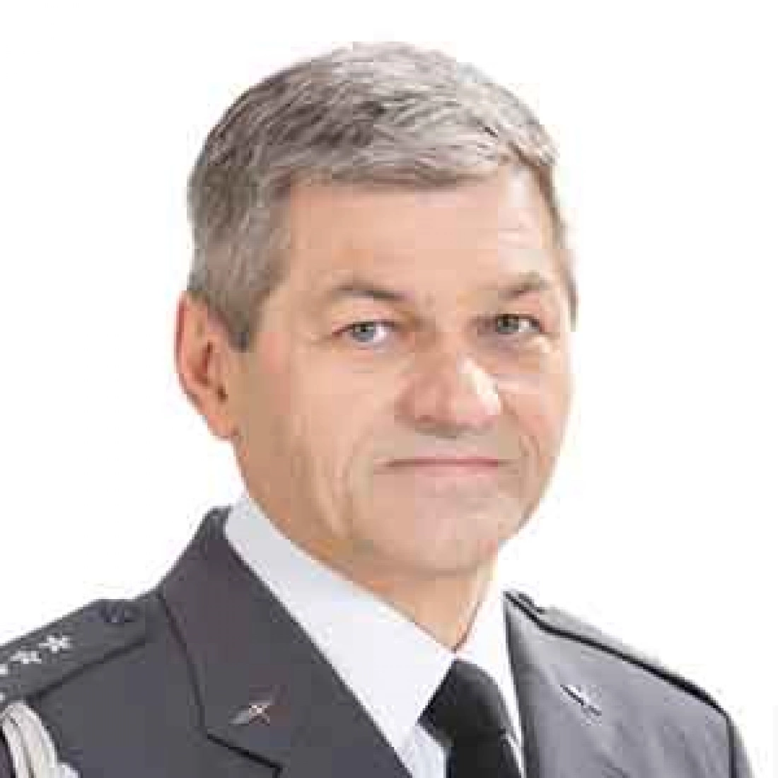 Mężczyzna w mundurze wojskowym z uśmiechem, z szarymi włosami.