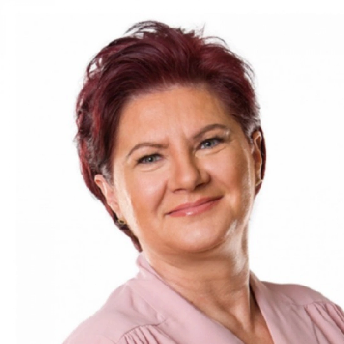 Kobieta z kr&oacute;tkimi czerwonymi włosami w garniturze, uśmiechająca się.