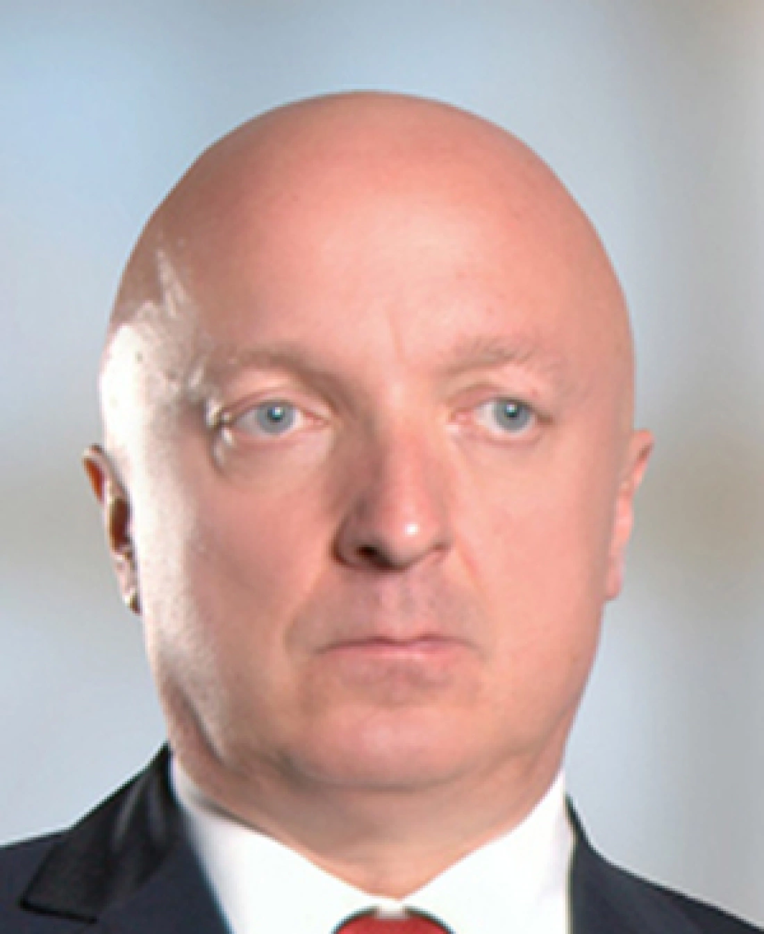 Mężczyzna w garniturze z łyżką głową i poważnym wyrazem twarzy.