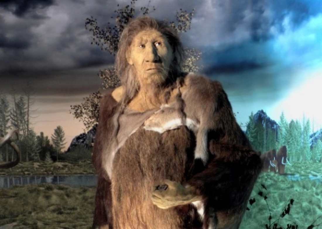 Prehistoryczna postać stojąca w naturalnym, leśnym krajobrazie.