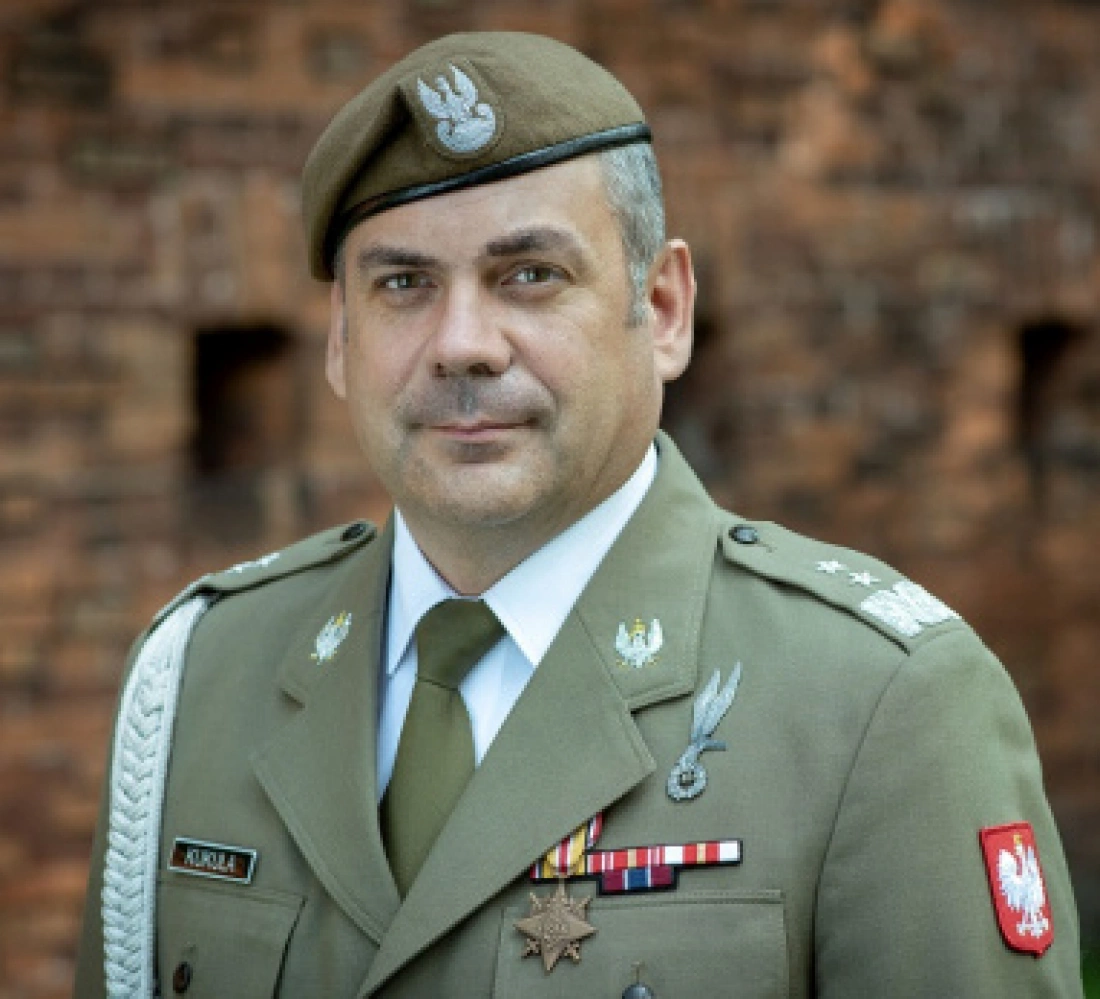 Mężczyzna w mundurze wojskowym z odznaczeniami i beretem.