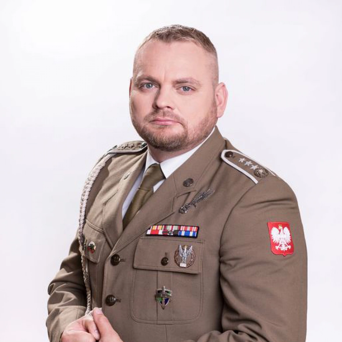 Mężczyzna w mundurze wojskowym z odznaczeniami i emblematem Polski.