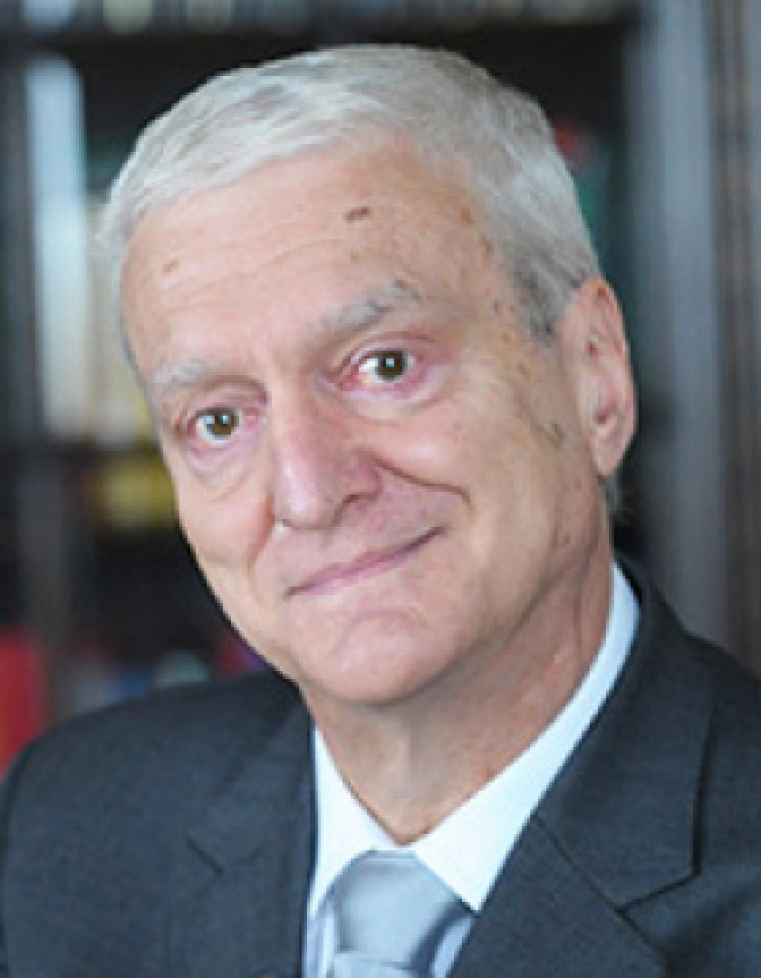 Mężczyzna w garniturze, uśmiechający się do kamery.