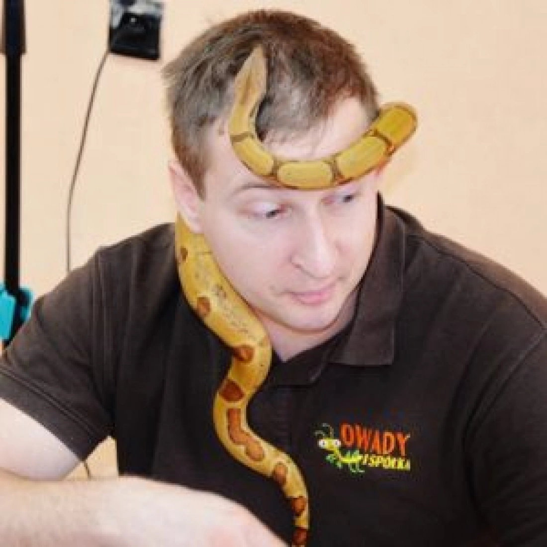 Mężczyzna z wężem owiniętym wokół szyi.