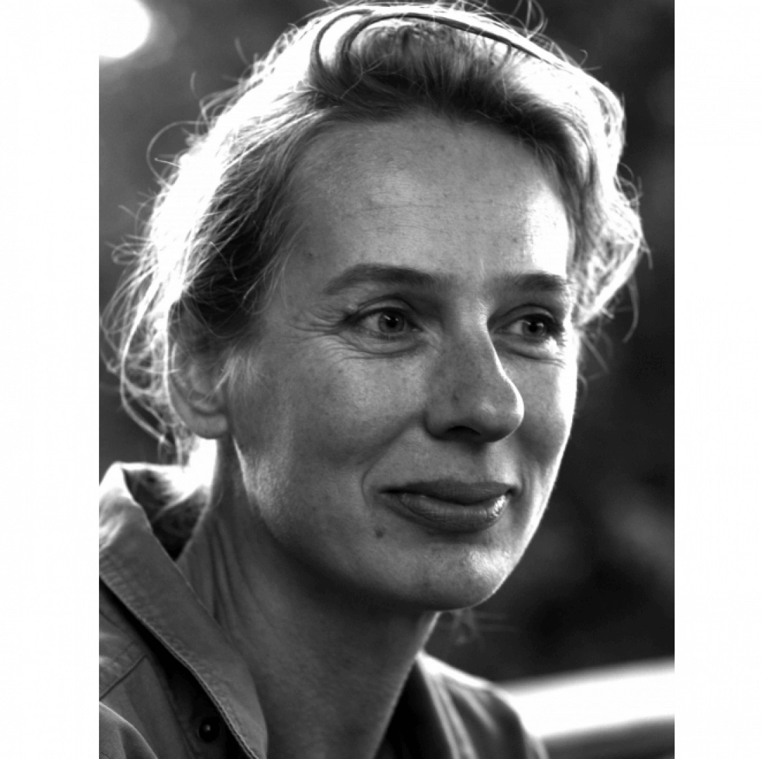 Portret kobiety w czarno-białej tonacji, z delikatnym uśmiechem.