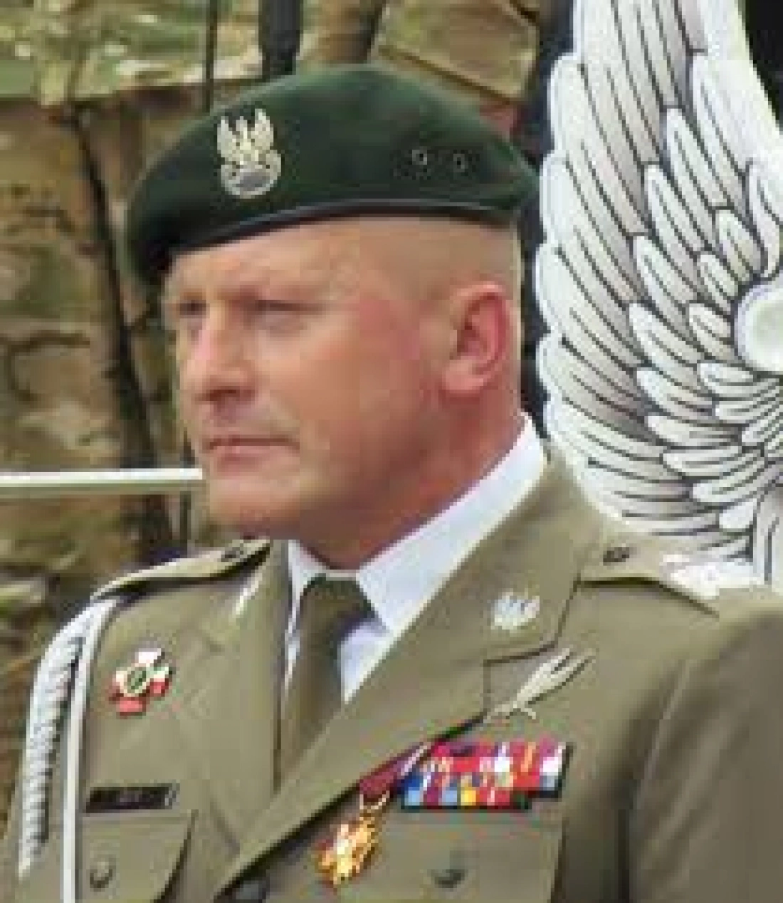 Mężczyzna w mundurze wojskowym z zieloną beretą i odznaczeniami.