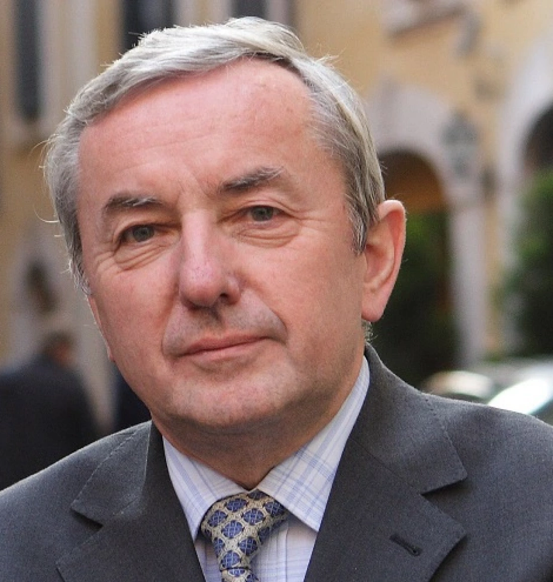 Mężczyzna w garniturze, stojący na ulicy.