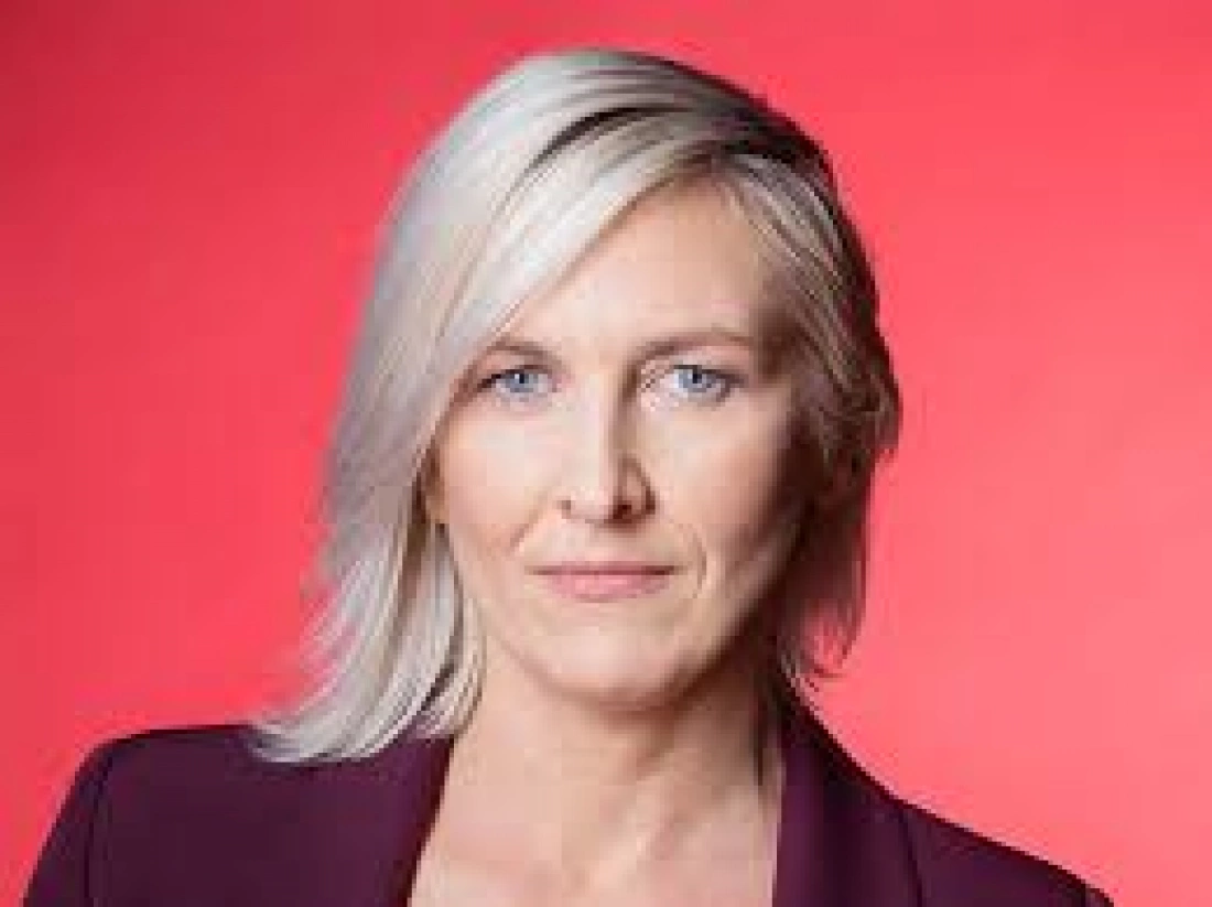 Portret osoby z jasnymi włosami na tle różowym.