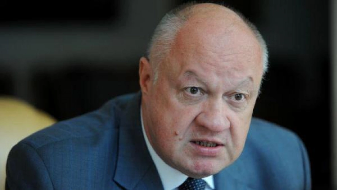 Mężczyzna w garniturze, wyglądający na zaniepokojonego, intensywnie rozmawia.