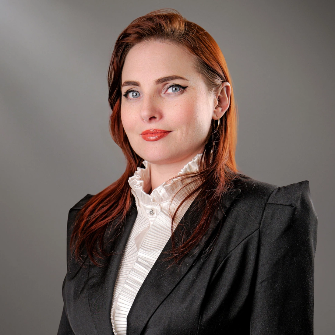 Sylwetka kobiety w białej koszuli na szarym tle.