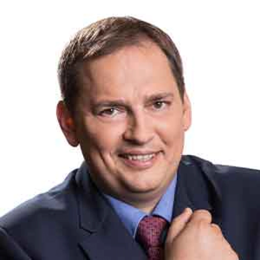 Mężczyzna w garniturze z uśmiechem na twarzy.