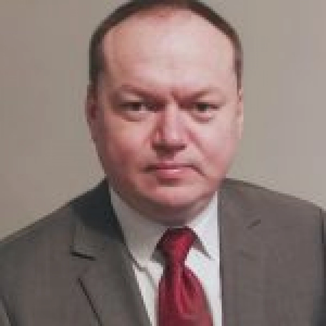 Mężczyzna w eleganckim garniturze i czerwonym krawacie.