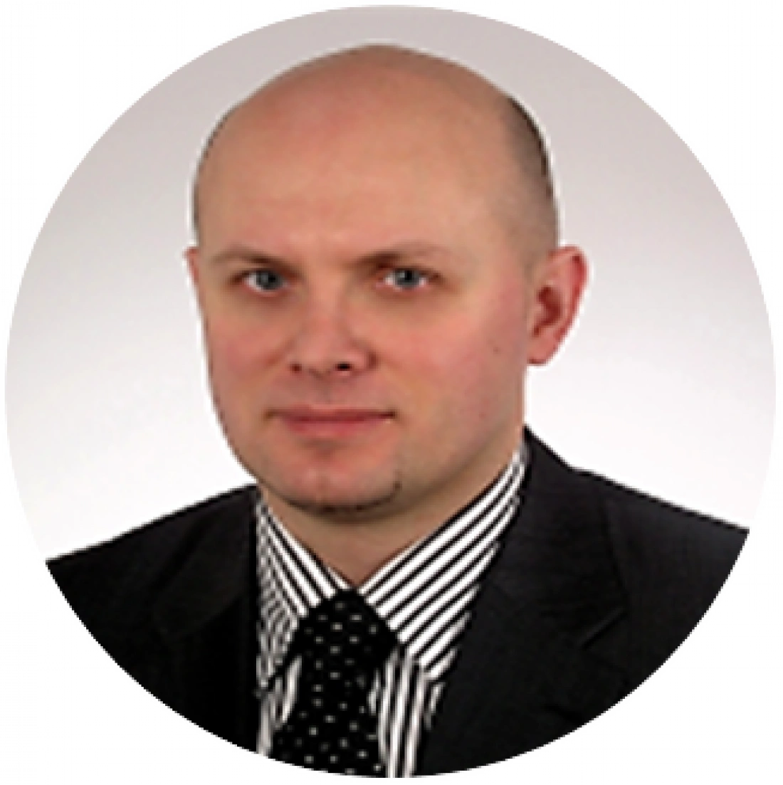 Mężczyzna w garniturze z krawatem, prezentujący poważny wyraz twarzy.