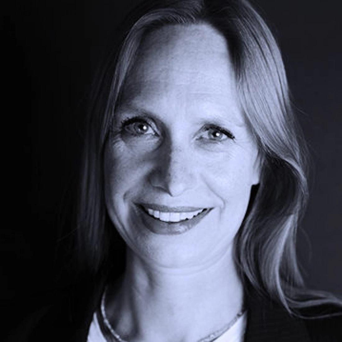 Przyjazny portret kobiety z długimi włosami i uśmiechem.