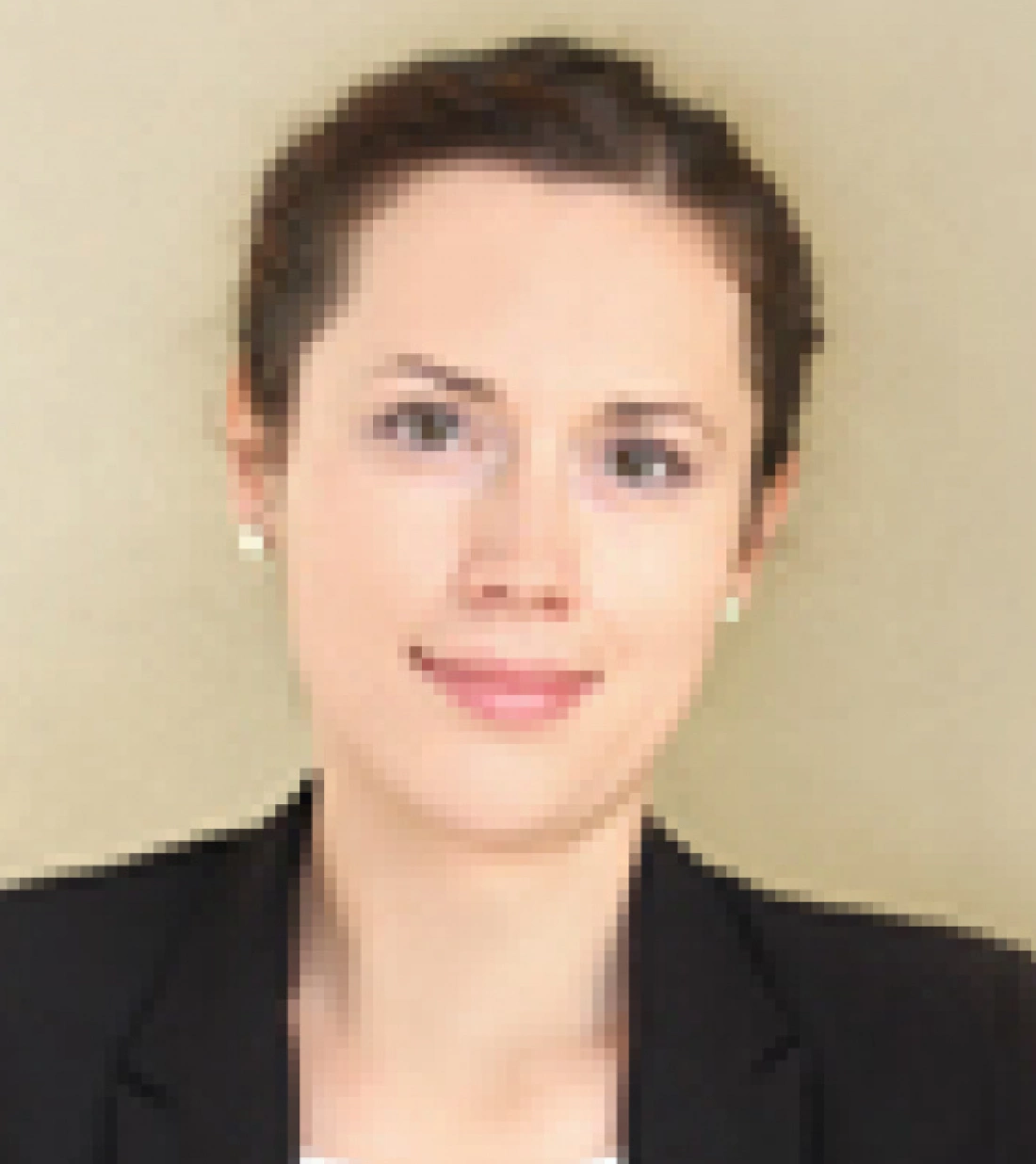 Portret młodej kobiety w garniturze na neutralnym tle.