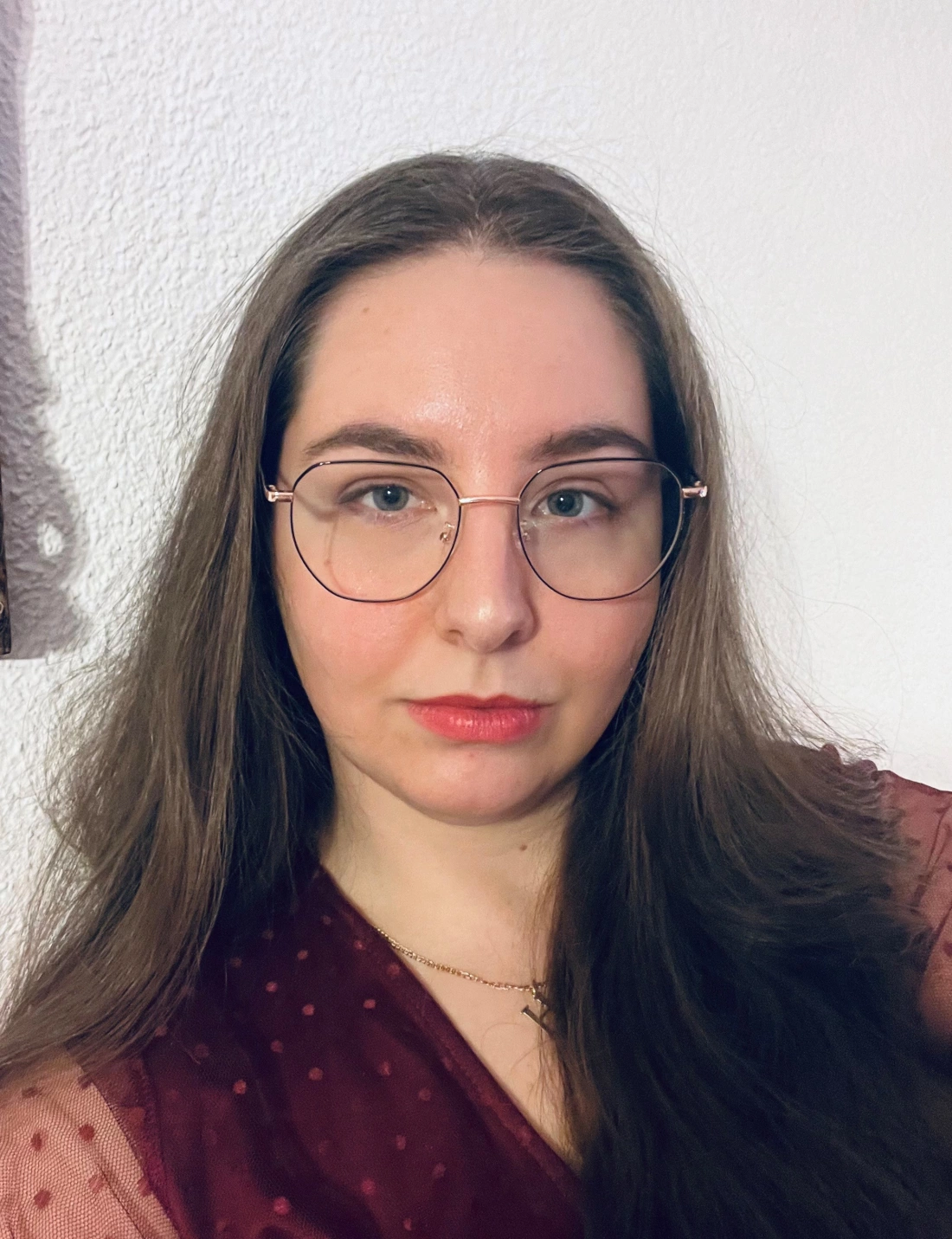 Kobieta z krótkimi włosami w okularach, ubrana na czarno, patrzy w obiektyw.