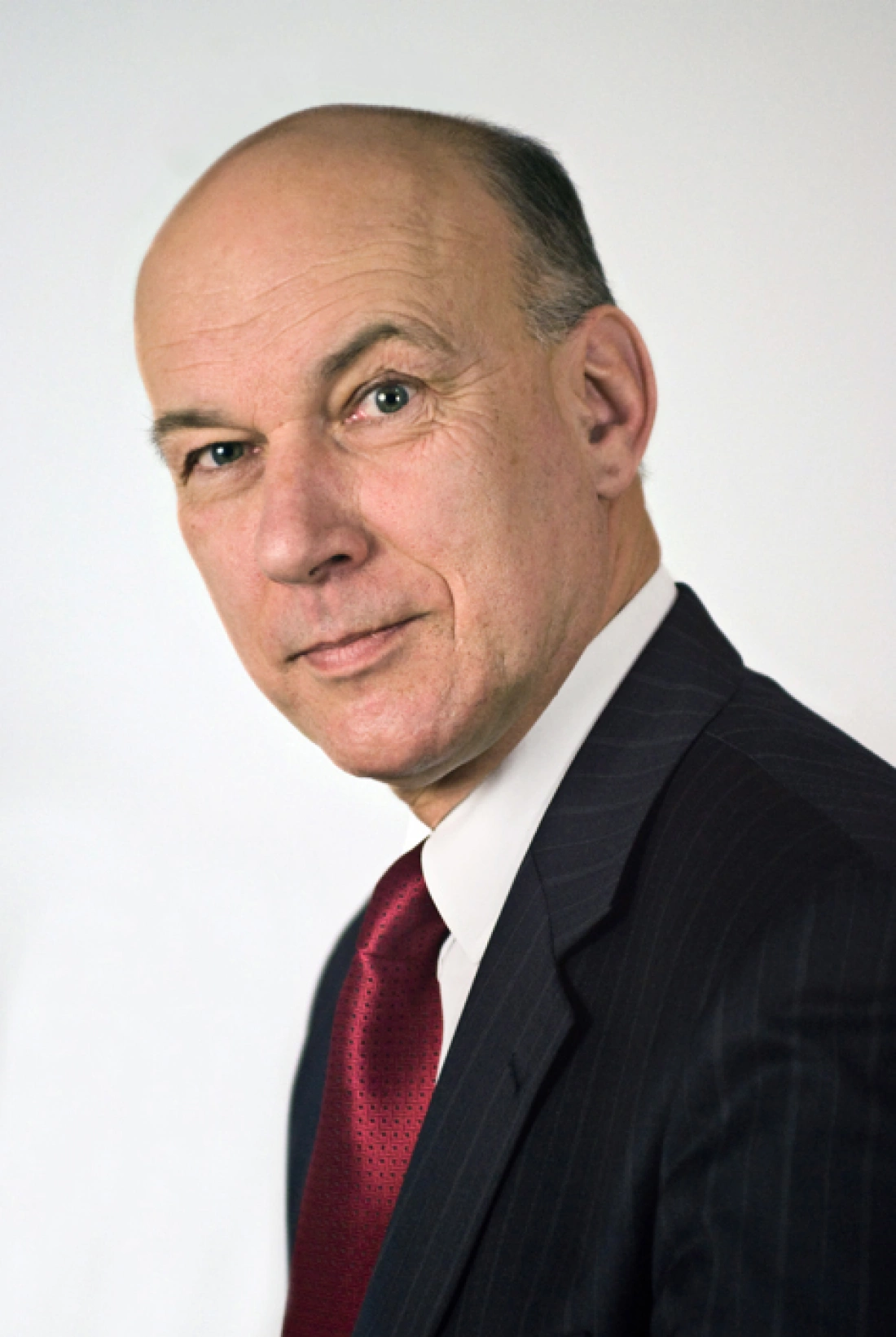 Mężczyzna w garniturze z krawatem, spoglądający w obiektyw.