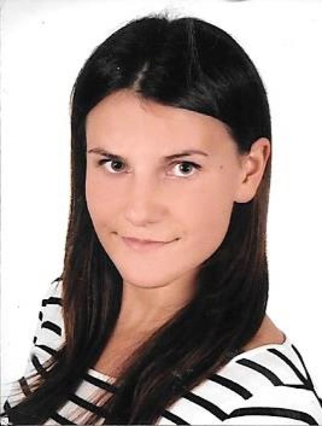 Portret młodej kobiety z długimi, ciemnymi włosami i uśmiechem, ubrana w bluzkę w paski.