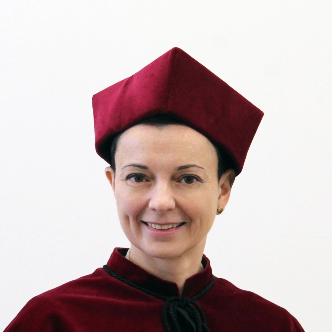 Kobieta w czerwonej todze z charakterystycznym nakryciem głowy.