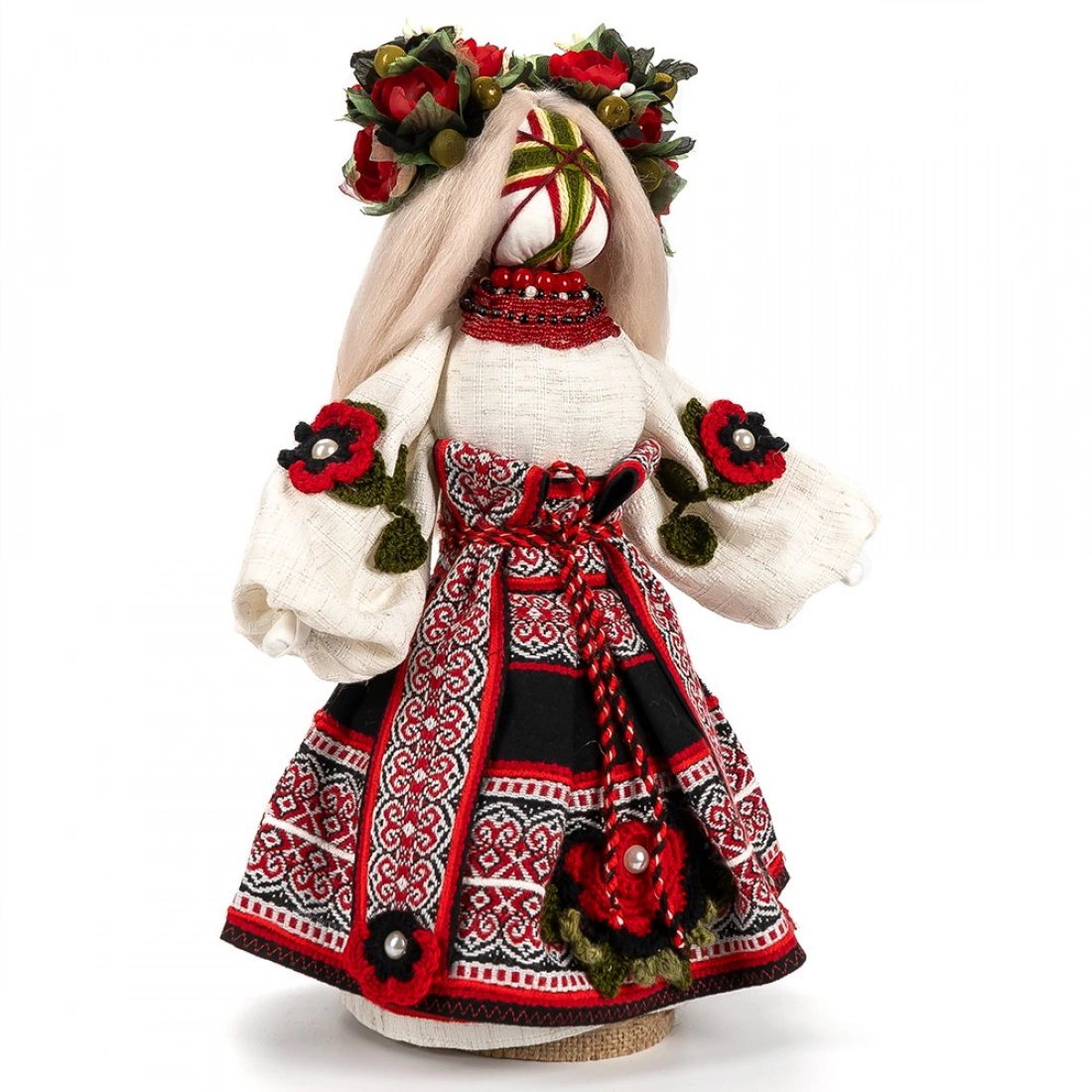 Lalka ludowa w tradycyjnym stroju z bogatymi haftami i czerwonymi akcentami.
