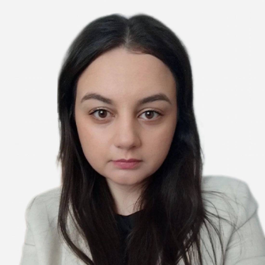 Młoda kobieta z długimi, ciemnymi włosami, ubrana w jasną marynarkę, patrzy prosto w obiektyw.