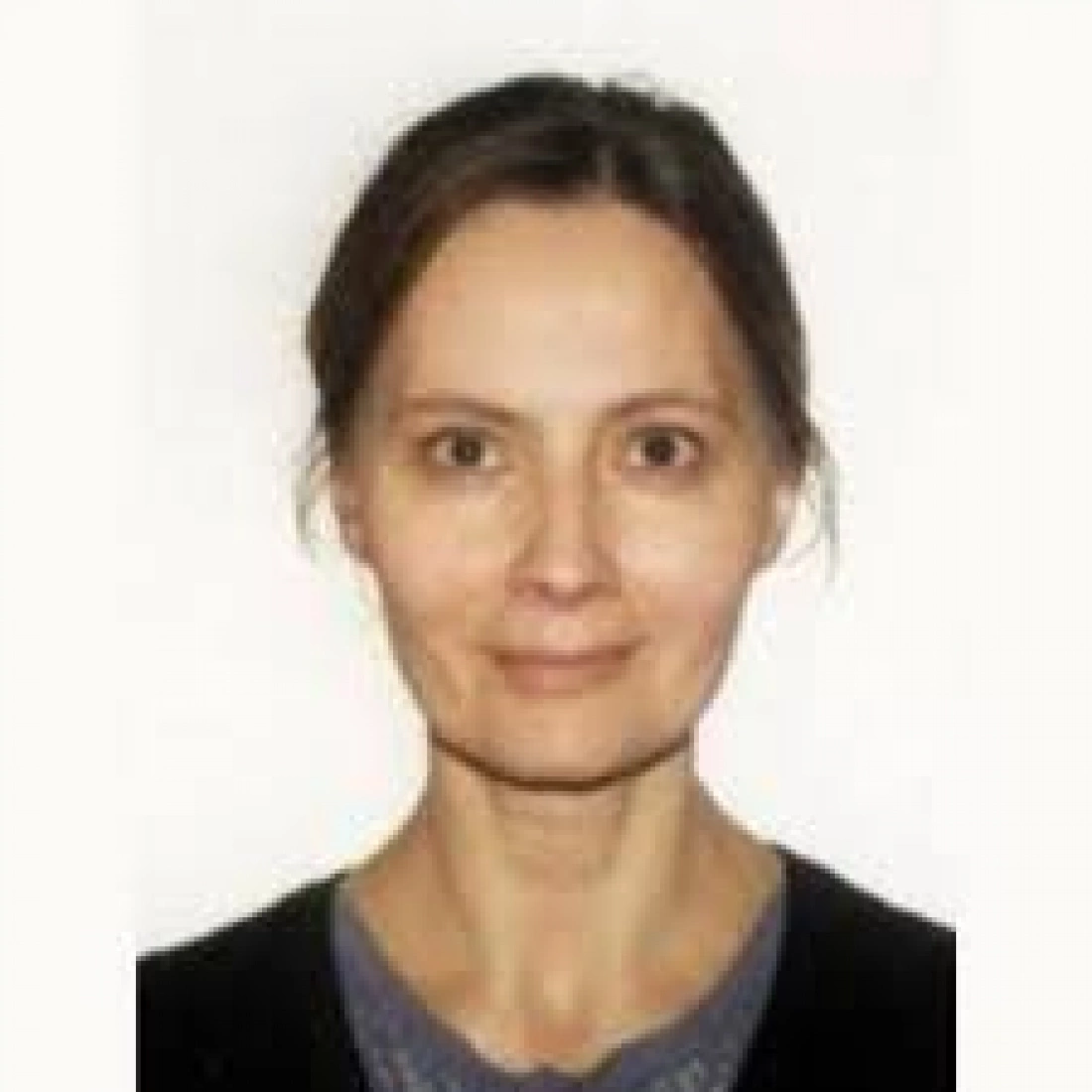 Portret kobiety z długimi włosami, uśmiechającej się lekko.