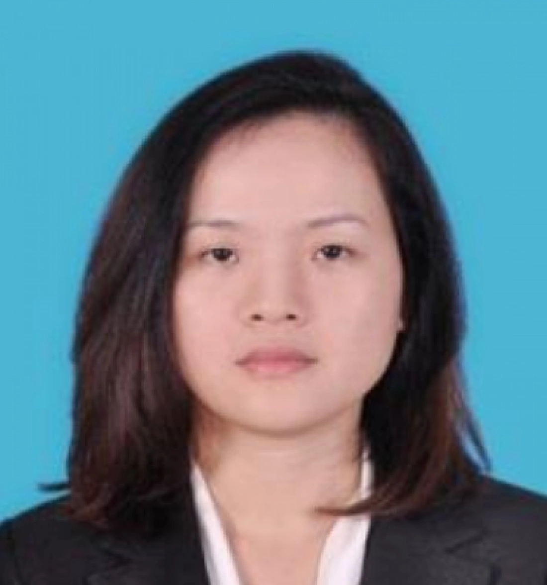 Portret kobiety w garniturze na jednolitym tle.