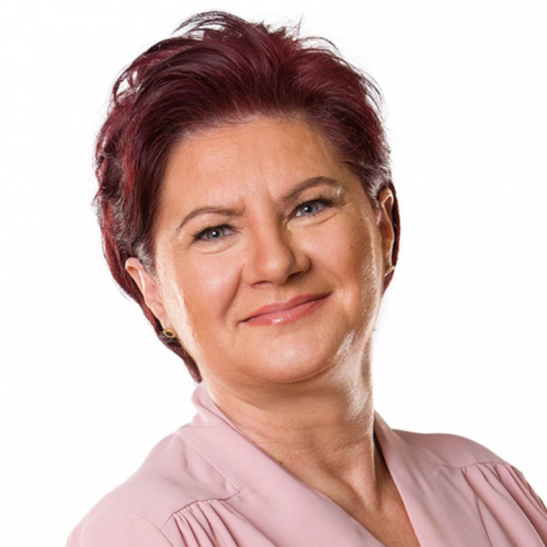 Kobieta z krótkimi, bordowymi włosami, uśmiechnięta, ubrana w różową bluzkę.