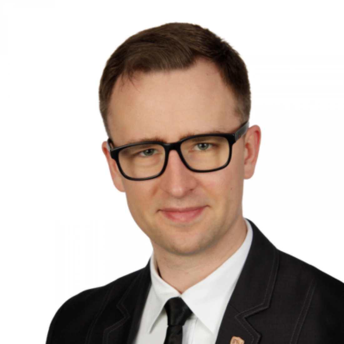 Mężczyzna w okularach, ubrany w elegancki garnitur.