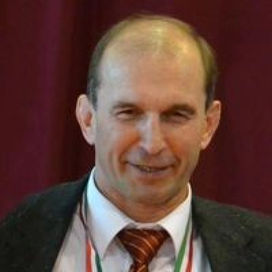 Mężczyzna w garniturze uśmiechający się.