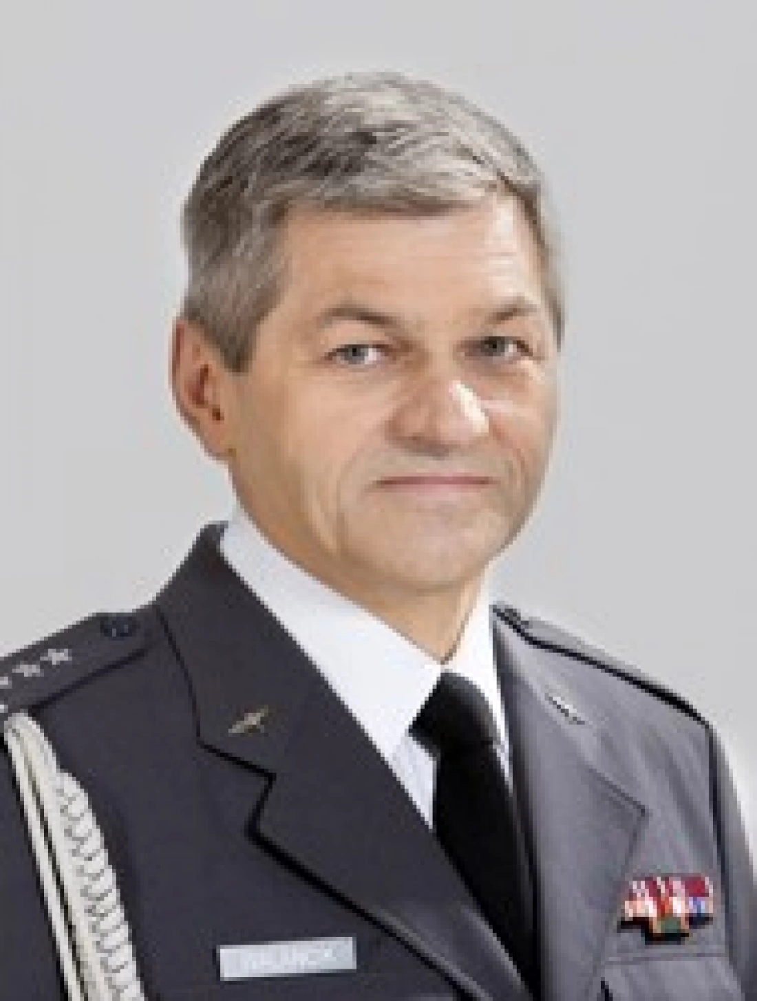 Mężczyzna w mundurze wojskowym, z poważnym wyrazem twarzy.