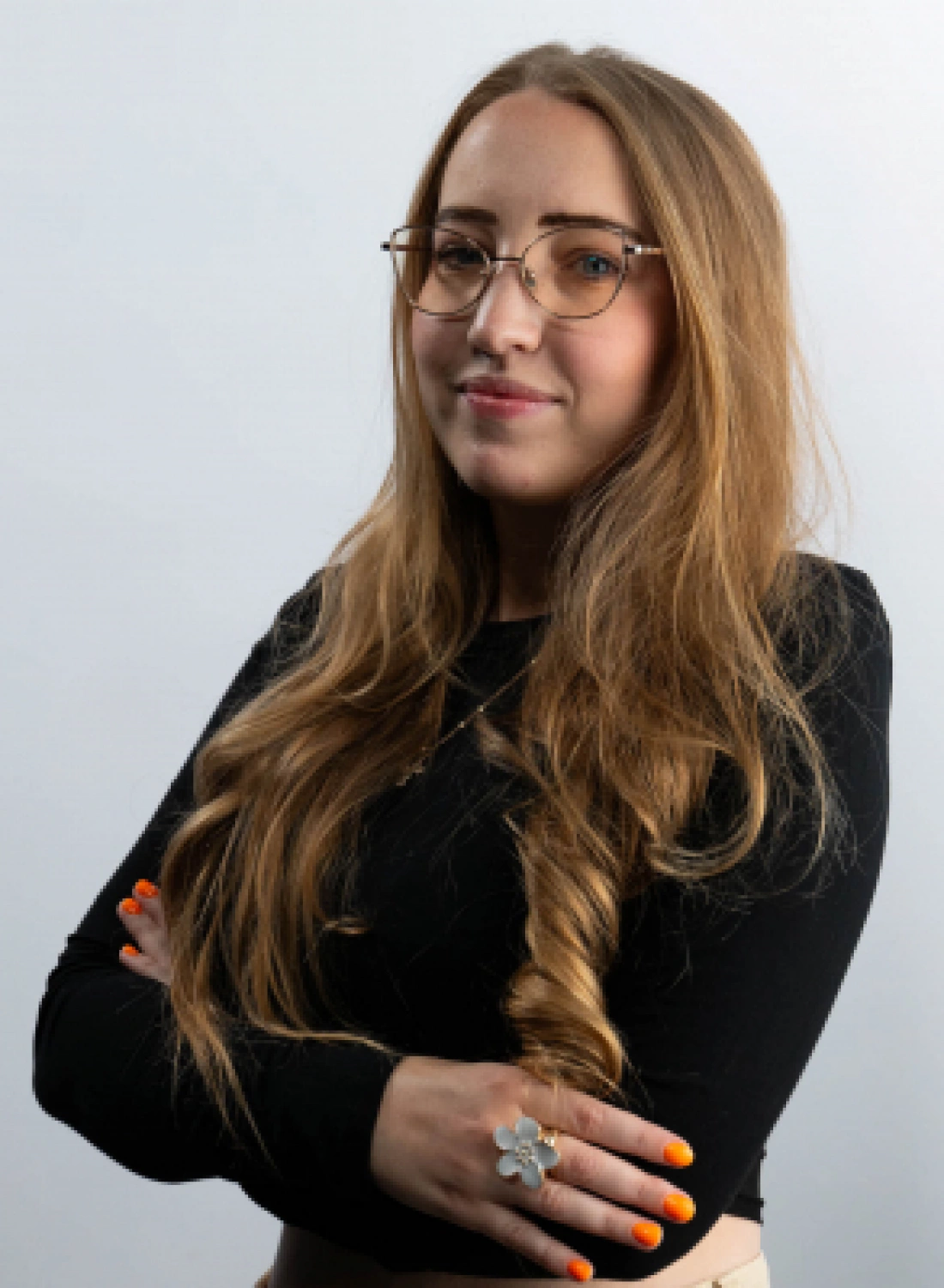 Kobieta z długimi, jasnymi włosami i okularami, ubrana w czarną bluzkę.